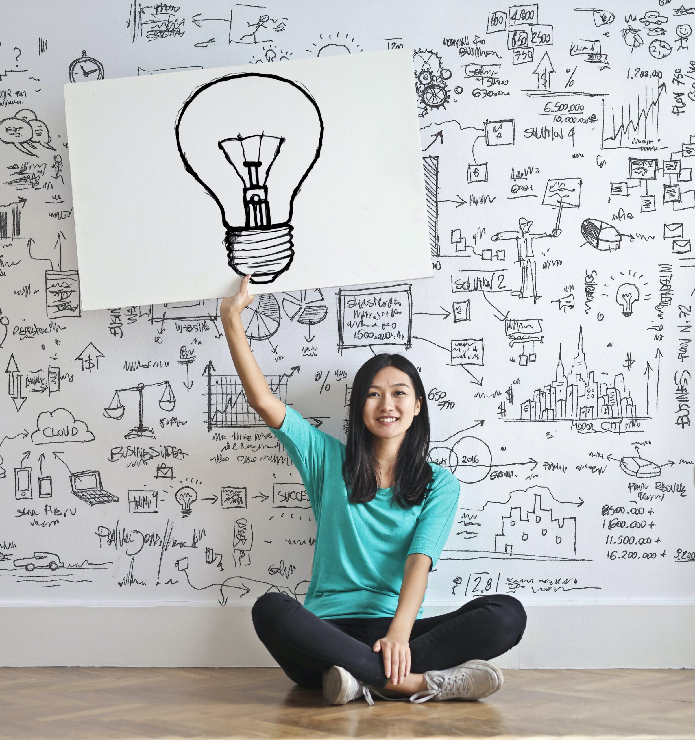 Happy Woman Holding sign With Lightbulb Drawn on It