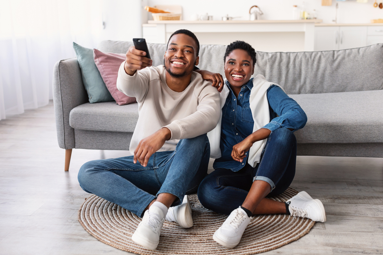 Portrait of Young Couple Relaxing on the Floor Watching Television