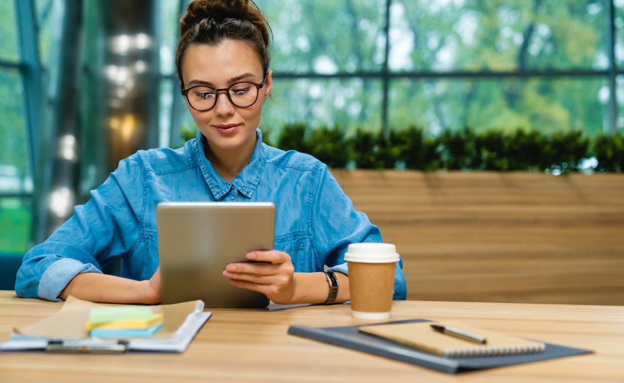 Businesswoman Sitting in Office with Digital Tablet