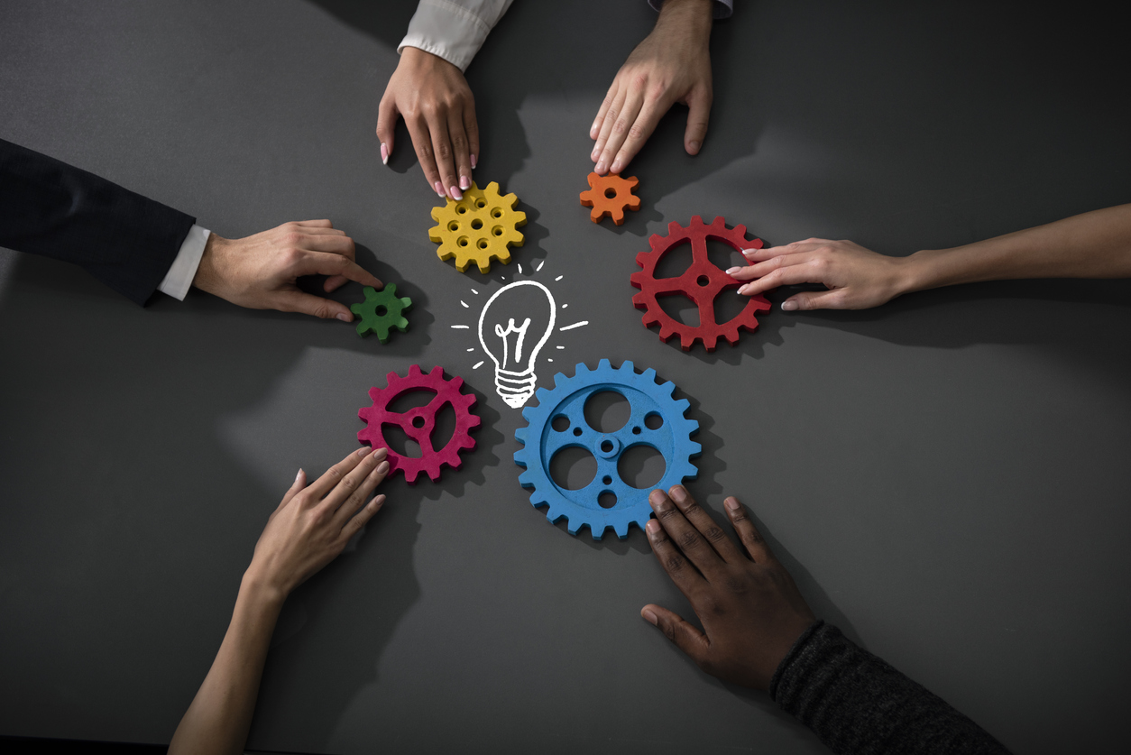 Business team connecting wooden pieces of gears