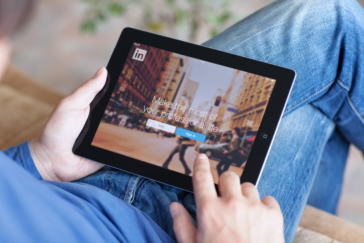 Man Holding Ipad With LinkedIn app on the screen