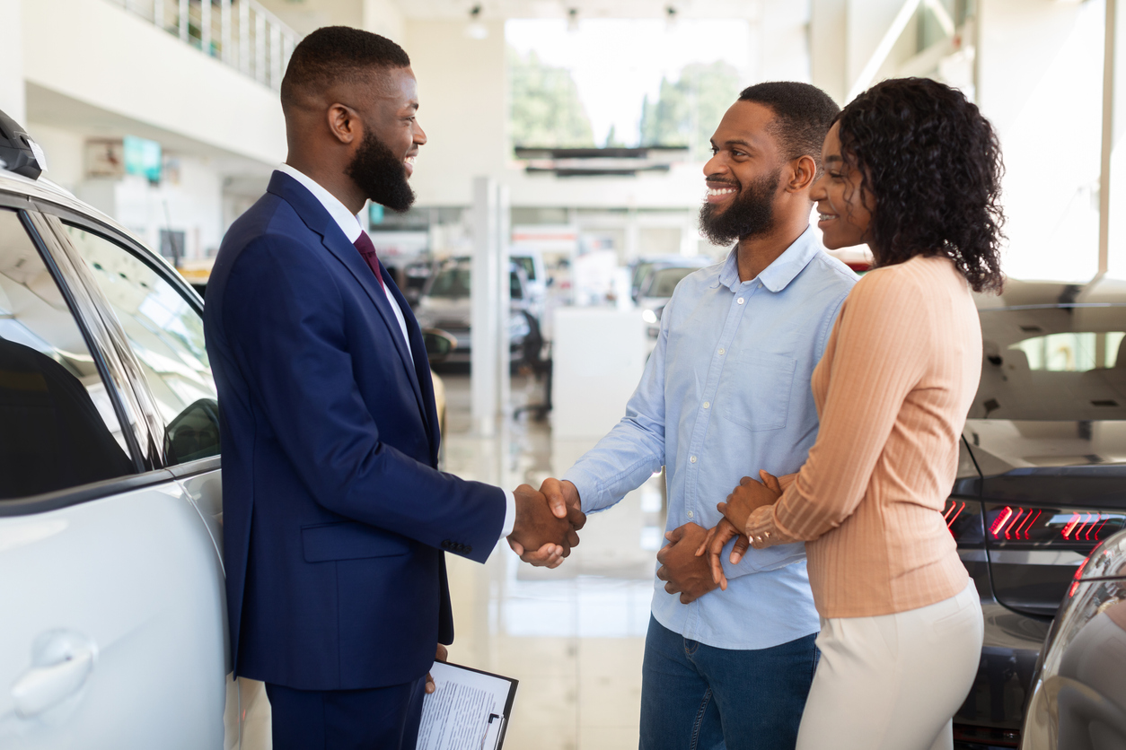 Couple shaking hands with care salesman