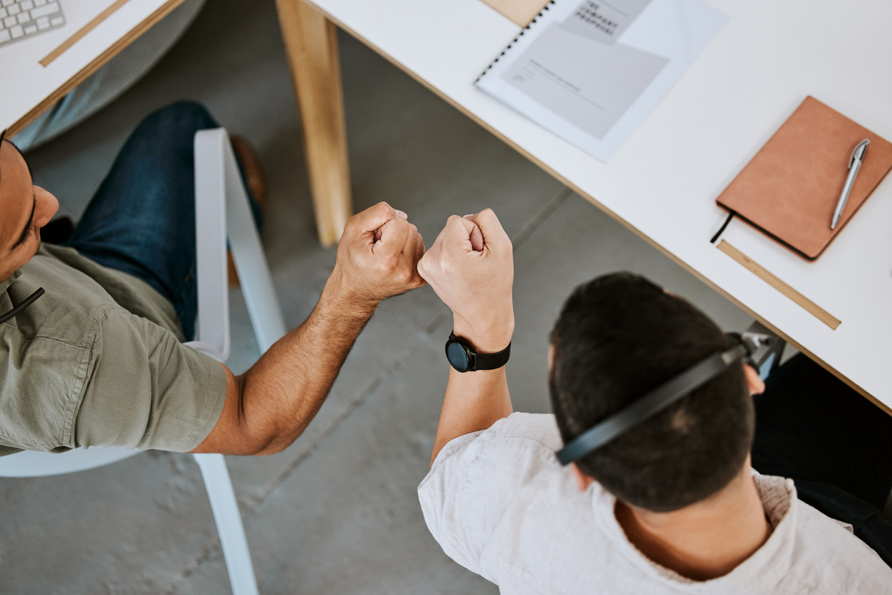 Two businessmen fist bumping