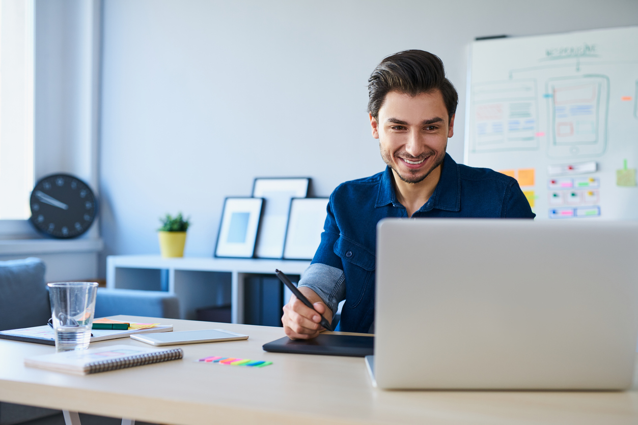 young business man smiling and looking at laptop